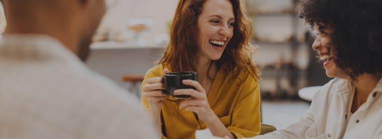 Laughing woman with coffee during lunch break